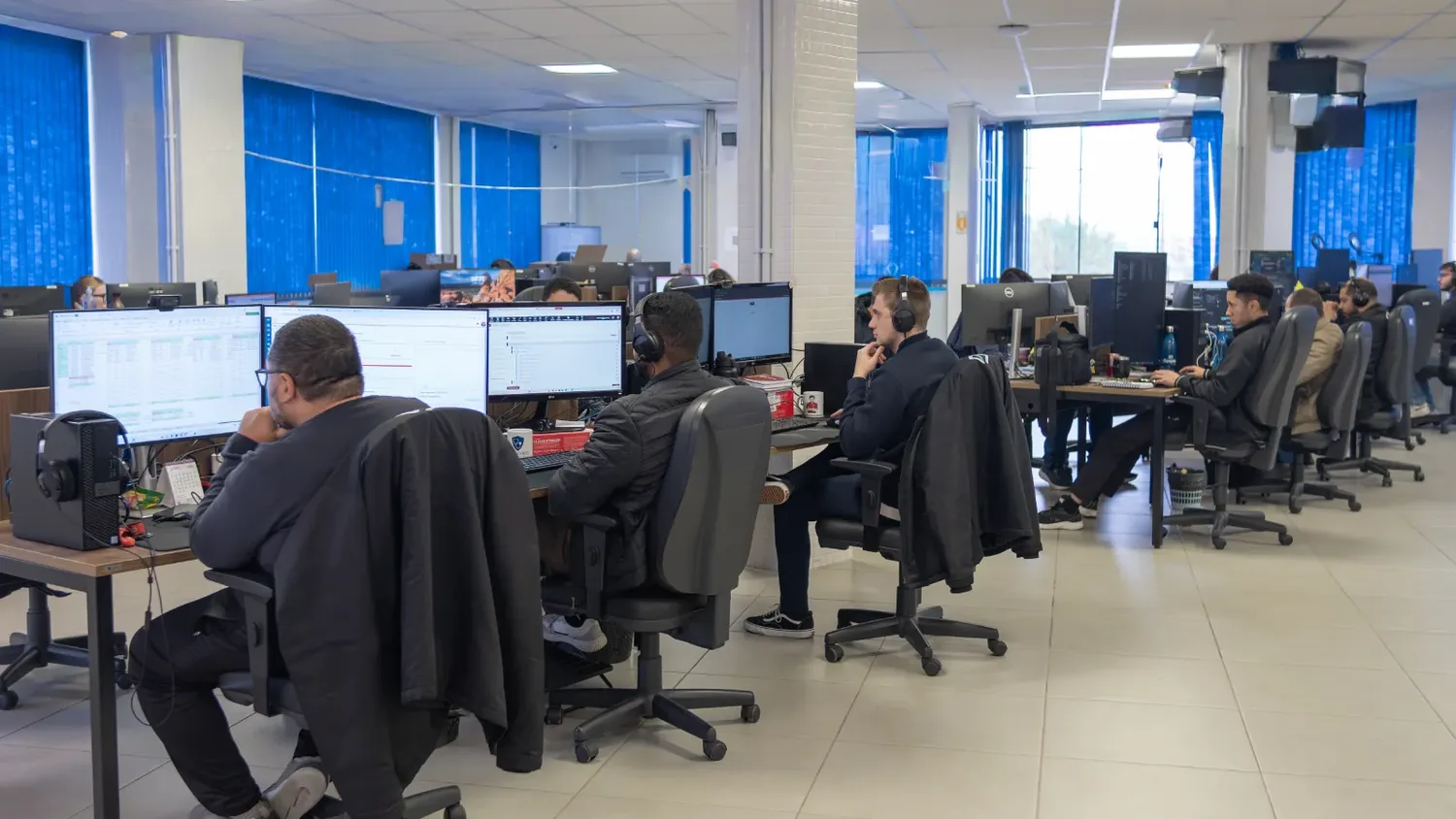 Equipe da Conplan trabalhando na sala de desenvolvimento, cada pessoa em sua estação com computador